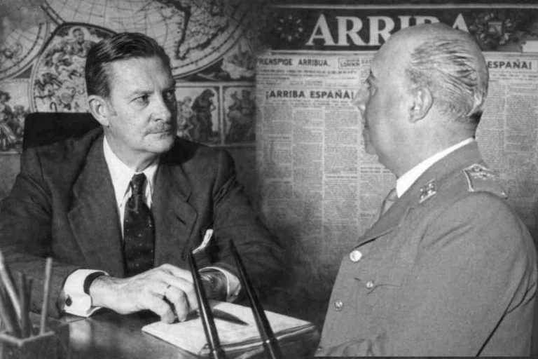 Director del diario Arriba sentado en su despacho en 1955, escribiendo en su mesa de trabajo con el periódico Arriba y un mapa de fondo, imagen alegórica de la entrevista de enero de 1955.