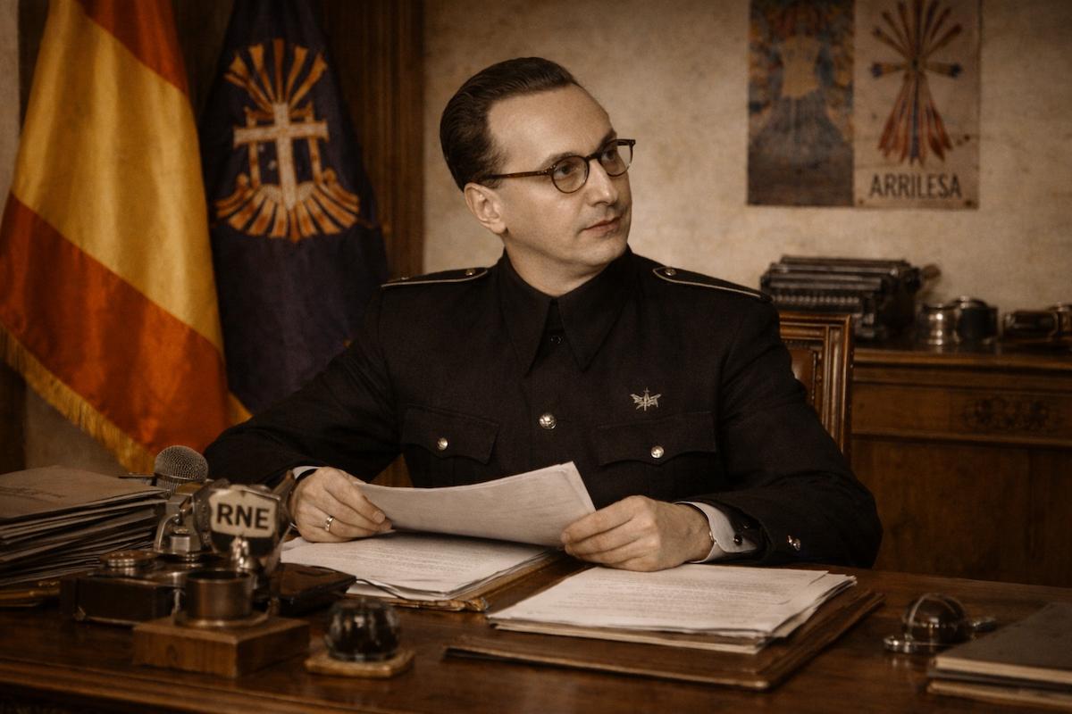 Fotografía alegórica en formato horizontal de Gabriel Arias-Salgado, sentado tras un escritorio en un despacho oficial, leyendo documentos. Viste uniforme oscuro y aparece rodeado de elementos institucionales de la época, con una bandera de España al fondo y ambiente solemne propio del franquismo.