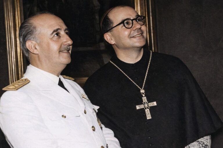 “Fotografía histórica coloreada de una visita institucional al Monasterio de Montserrat en 1960, con autoridades civiles y un representante religioso observando una obra o espacio del recinto.”