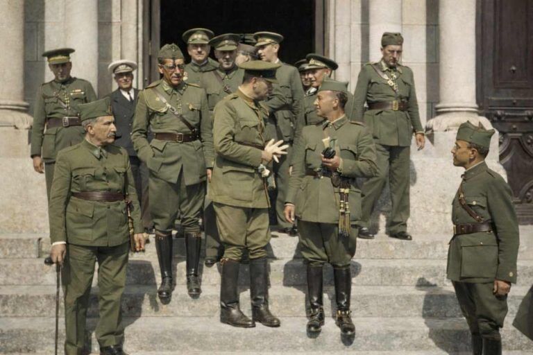 Fotografía histórica coloreada de oficiales del ejército español en 1936 frente a un edificio institucional, con uniformes y gorras del mismo color durante la Guerra Civil española.