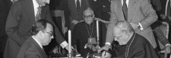 Firma del Concordato entre la Santa Sede y España en 1953, con representantes del régimen franquista y autoridades eclesiásticas reunidos en torno a la mesa durante la rúbrica del acuerdo.