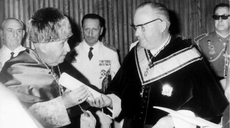 Acto académico en la Universidad de Santiago de Compostela en 1965, donde una autoridad universitaria entrega el diploma de doctor «honoris causa» en una ceremonia solemne, rodeados de autoridades civiles y militares.