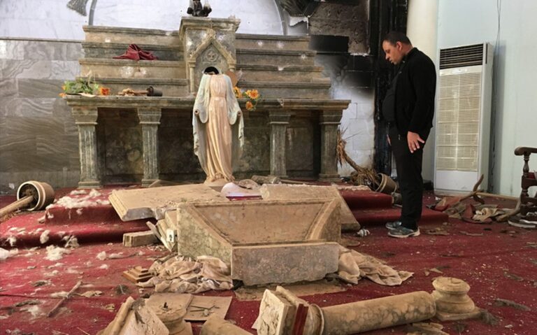 nterior de una iglesia vandalizada con el altar destruido y una estatua religiosa decapitada, mientras un hombre observa los destrozos en el templo.