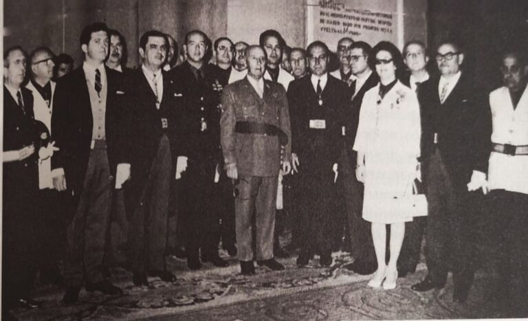 Grupo de autoridades y representantes reunidos en Sevilla en 1963 durante el acto del Consejo Económico Sindical, con Francisco Franco en el centro rodeado de hombres y una mujer en primera fila.