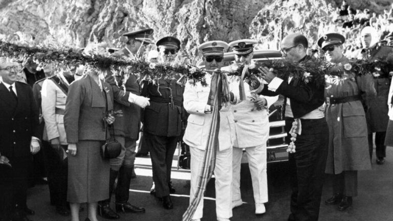 Autoridades y militares durante la inauguración de una infraestructura, cortando una cinta ceremonial rodeados de público y escolta oficial en un entorno montañoso.