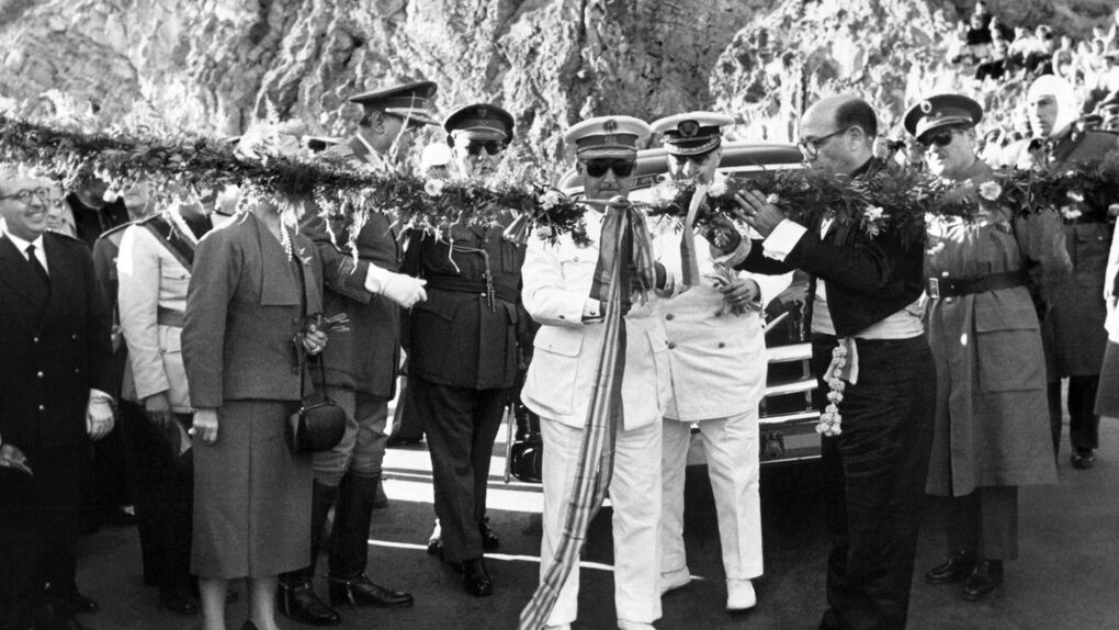 Autoridades y militares durante la inauguración de una infraestructura, cortando una cinta ceremonial rodeados de público y escolta oficial en un entorno montañoso.